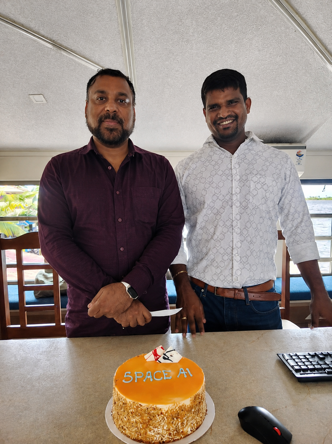 Space AI founders celebrating with a company cake